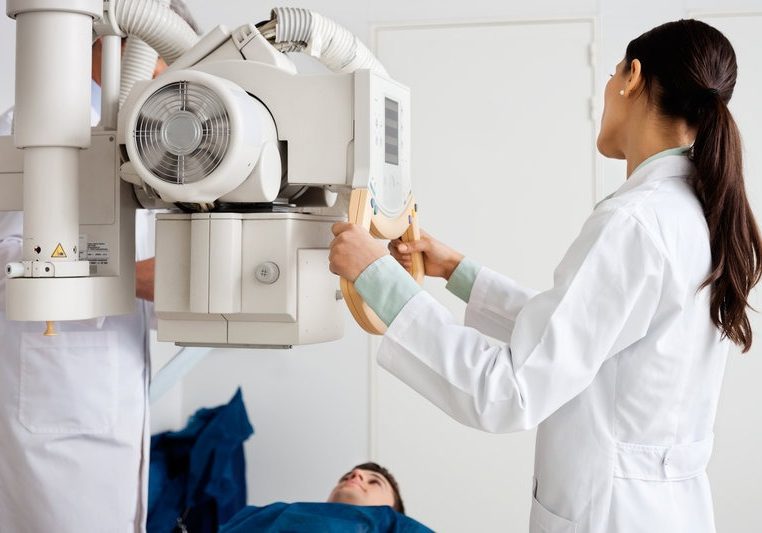 Female Radiologist Performing X-ray On Patient